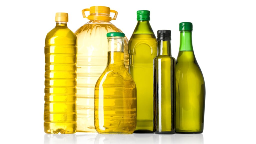 A collection of various olive oil bottles in different shapes, sizes, and colors, including clear and dark glass, as well as plastic containers.