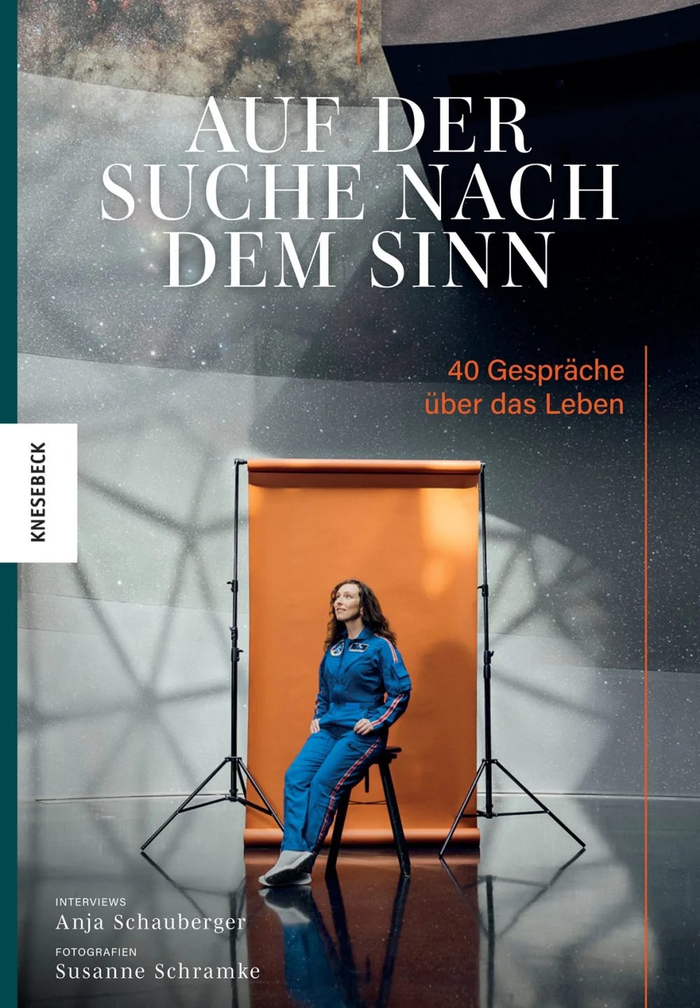 Das Cover des Buches Auf der Suche nach dem Sinn zeigt eine dunkelhaarige Frau im blauen Overall vor einer orangefarbenen Leinwand.
