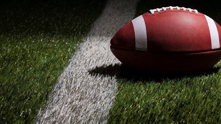 Low angle view of a football at a yard line with dramatic lighting - stock photo (Willard/Getty Images)