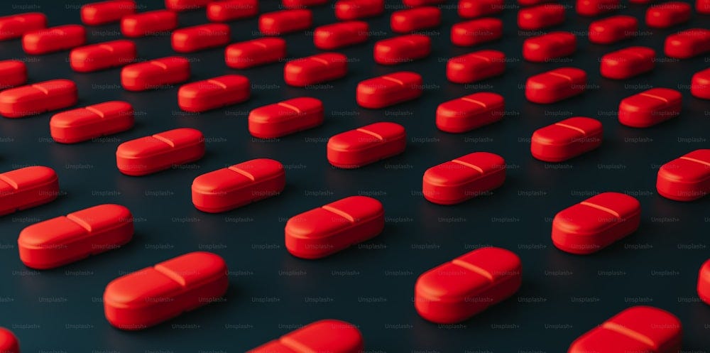 many red pills are arranged on a black surface