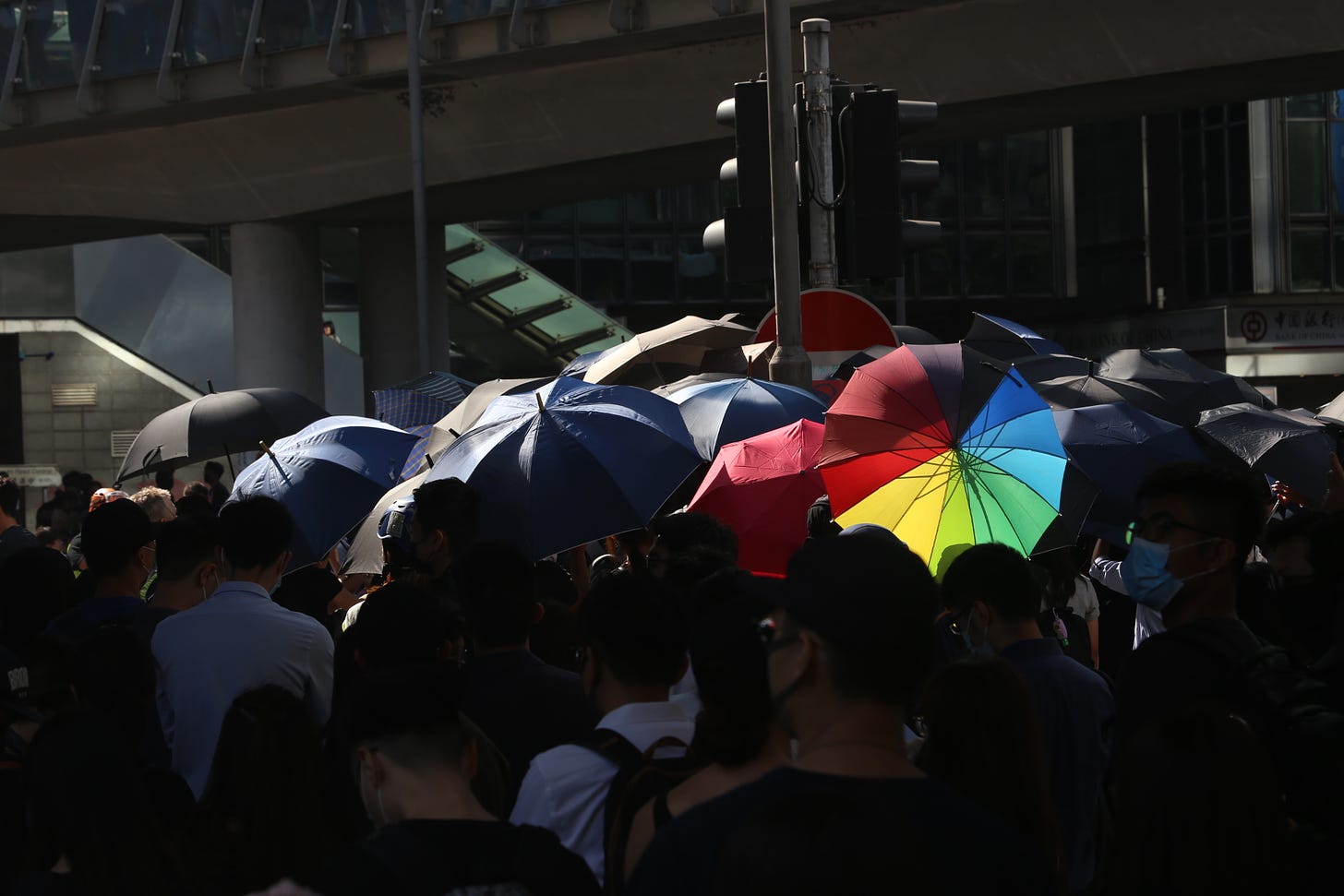 A crowd of people hold up colorful umbrellas to shield their protest actions in Hong Kong in 2019