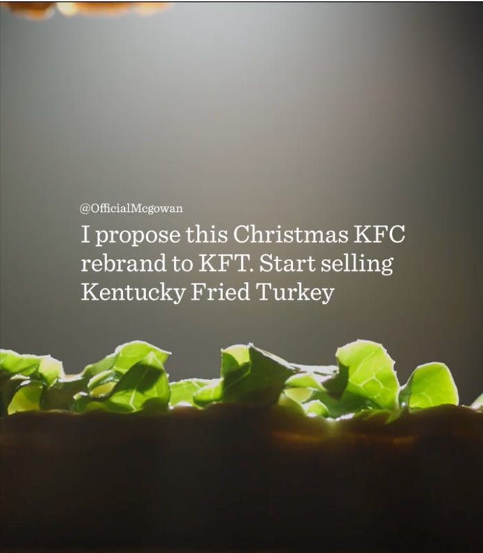 a social media post suggestion with the text: "@OfficialMcgowan I propose this Christmas KFC rebrand to KFT. Start selling Kentucky Fried Turkey." The text is overlaid on a blurred background that seems to be a close-up of a sandwich with lettuce.