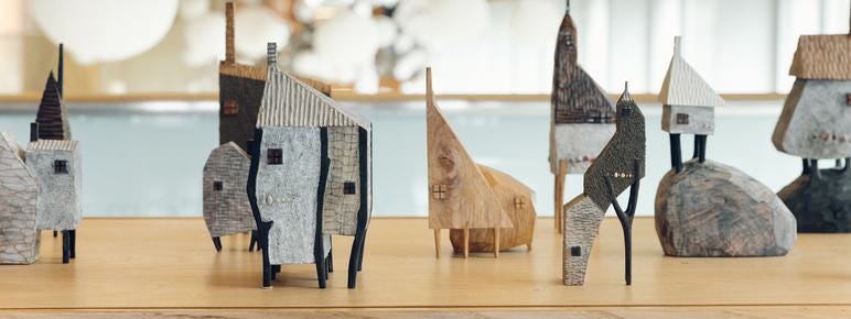 A display of miniature carved wooden houses.