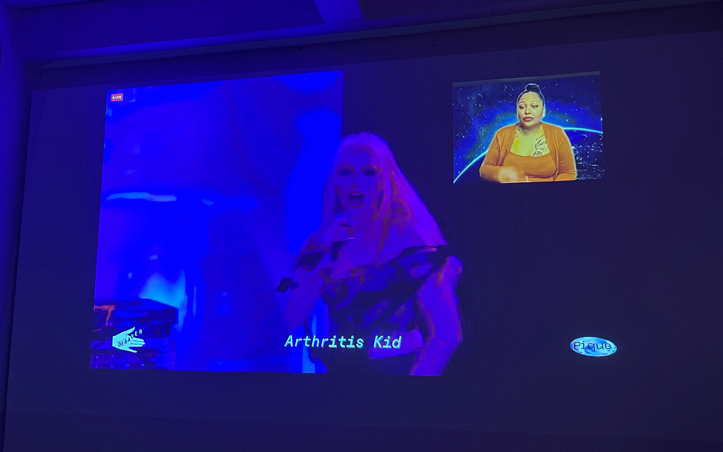 A live feed from a performance shows a performer labeled Arthritis Kid and an ASL interpreter.