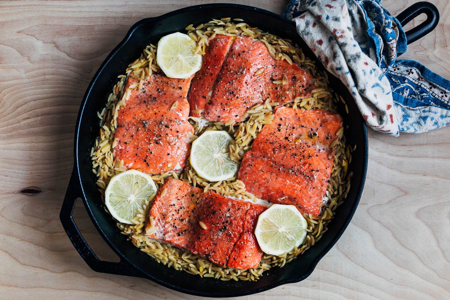 Cooked orzo and salmon in a cast iron skillet
