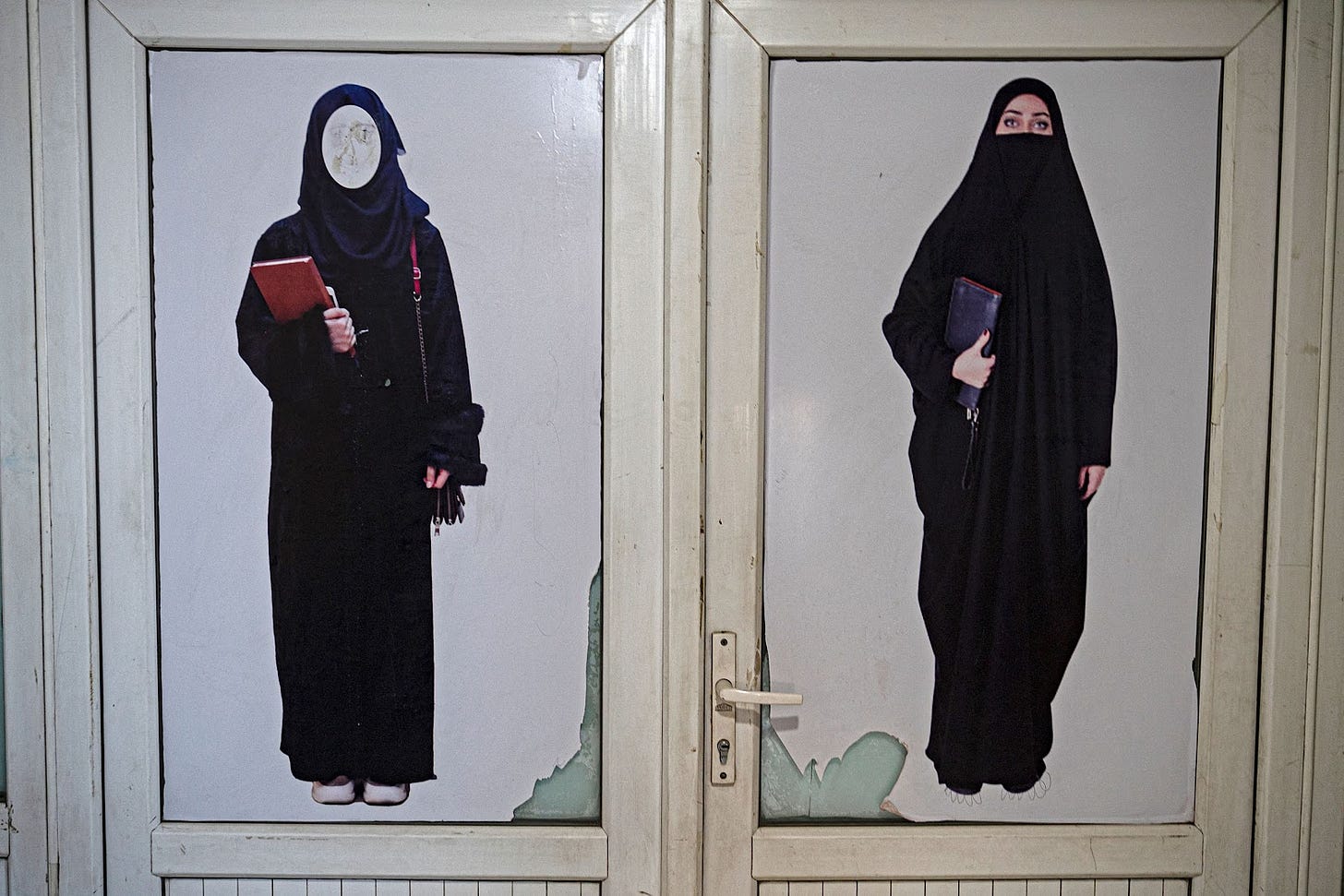<p>A poster pasted on a door ordering women to cover themselves with a hijab is pictured at a private university in Kabul</p>