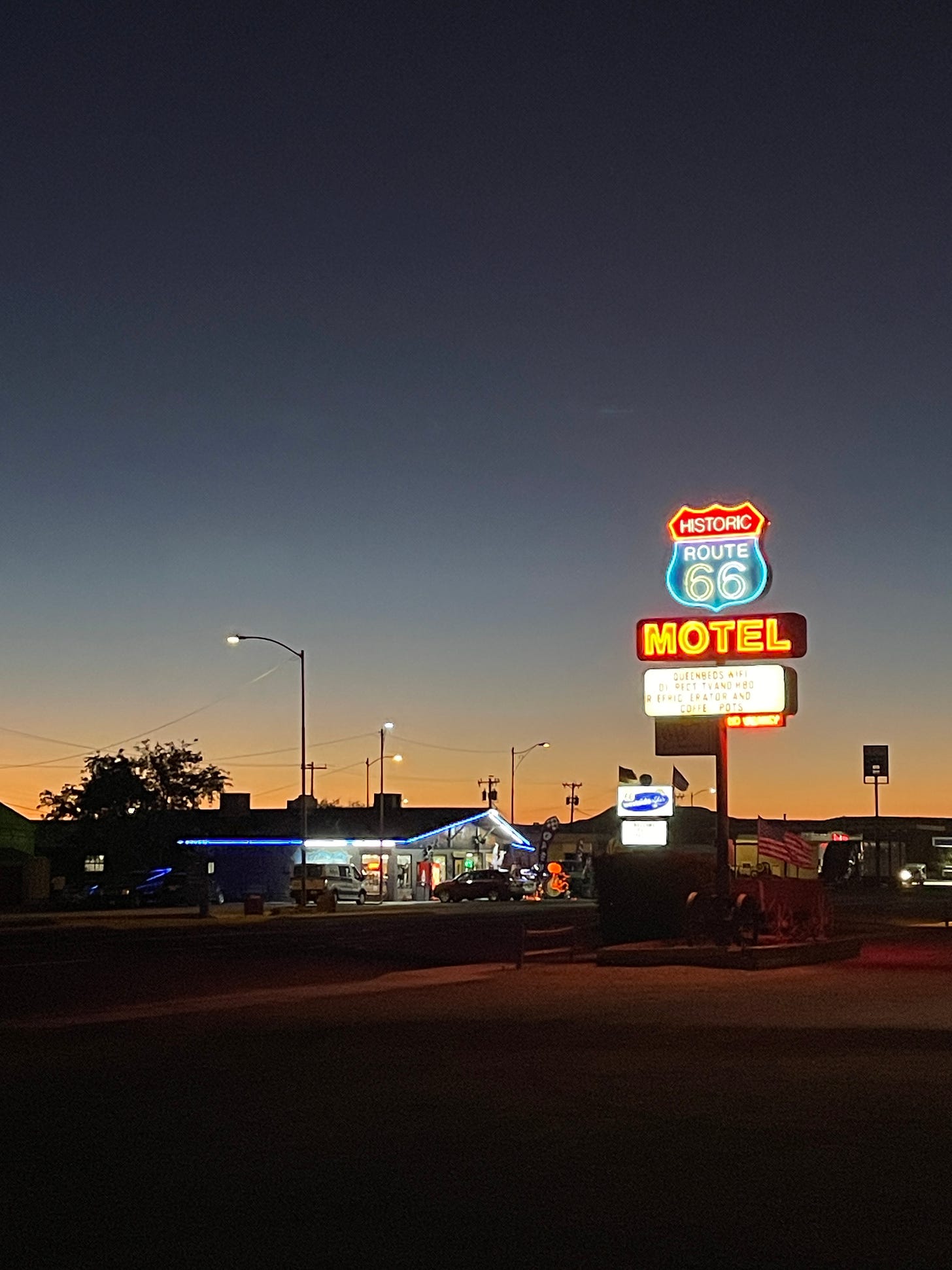 The small town of Seligman, AZ at dusk. A bright neon sign reads "Historic Route 66"