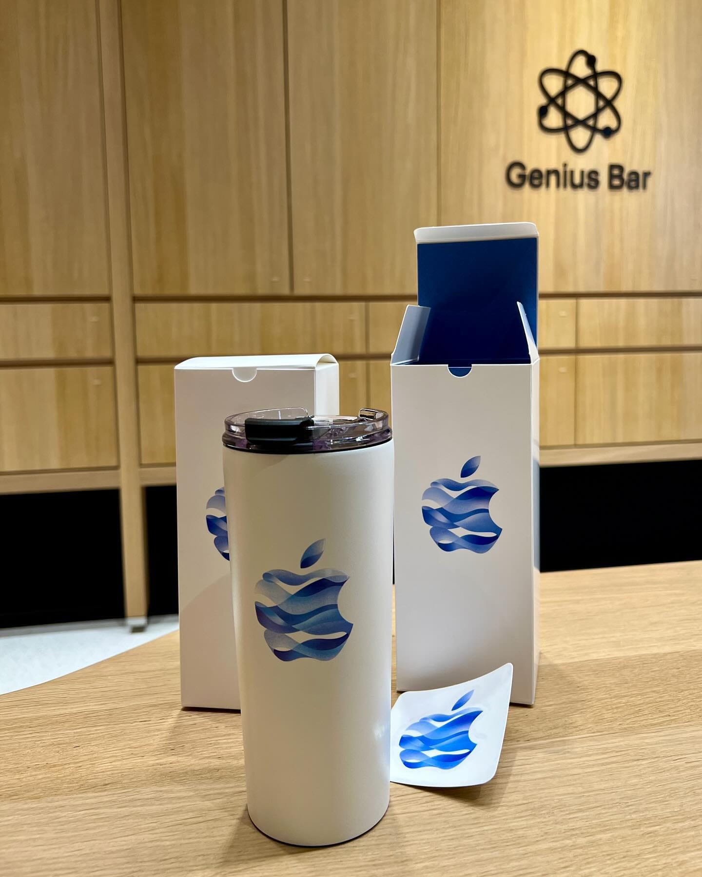A tumbler, box and sticker given to visitors at Apple Hanam. The souvenirs are pictured on the store's Genius Bar.