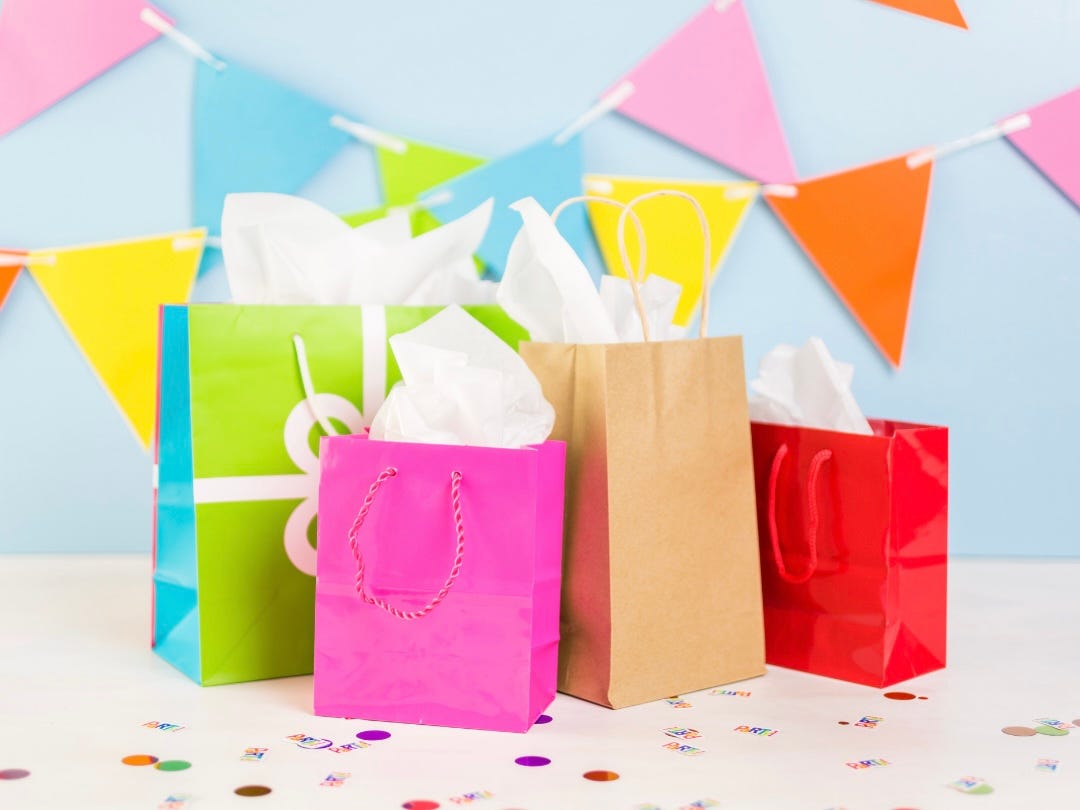 Image shows brightly colured paper party bags and bunting.