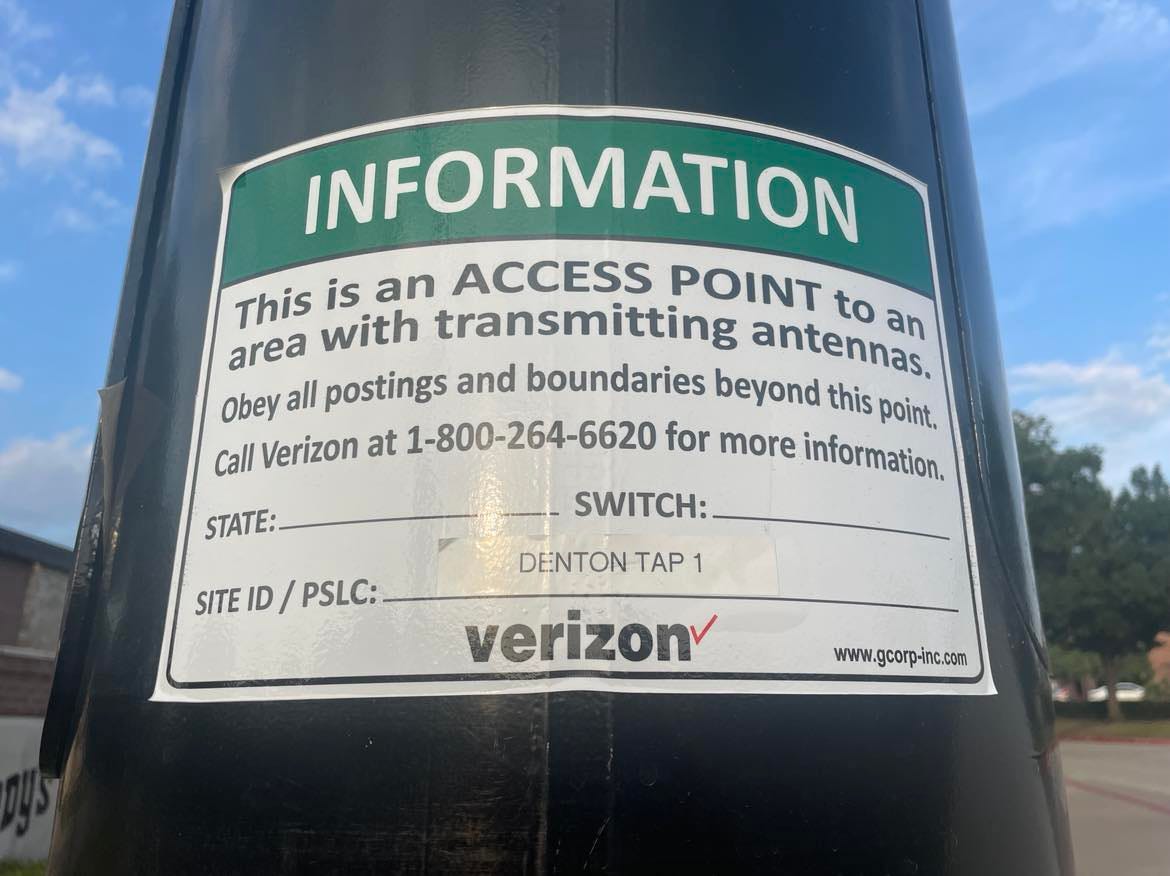 A sticker that says, "This is an ACCESS POINT to an area with transmitting antennas." The sticker also features the Verizon logo and a 1-800 number to call for more information.