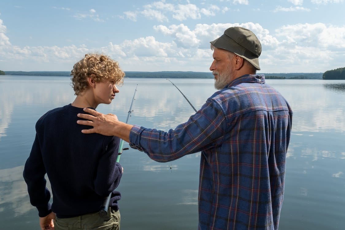 Free An Elderly Man Holding His Grandson's Shoulder while Looking at Him Stock Photo