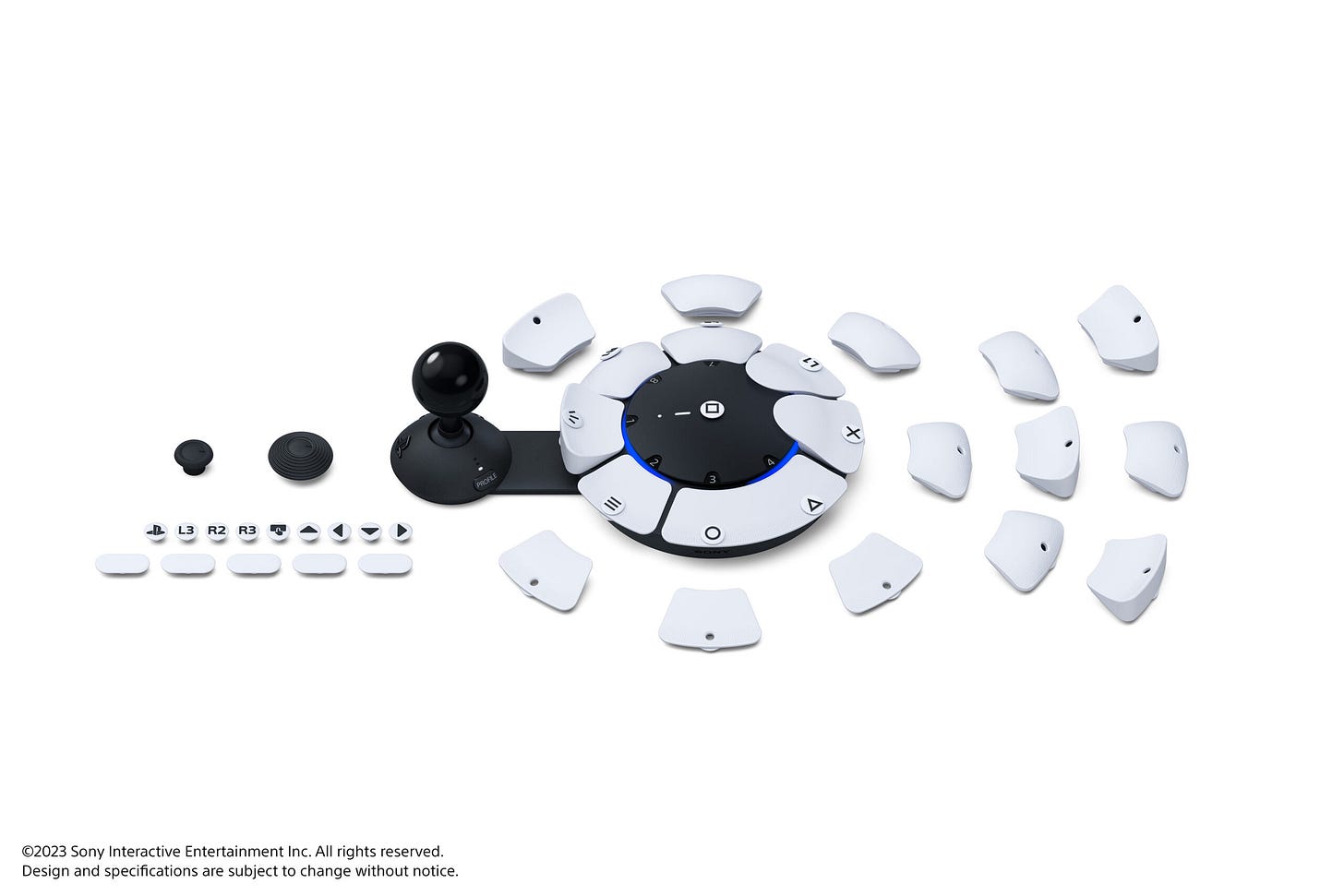 A product packaging for The Playstation Access™ controller, featuring a white background with a diagram of the product and buttons. The packaging is accompanied by several objects, including a plane, buttons, joystick, arranged in a way that suggests they are related to the The Playstation Access™ controller.