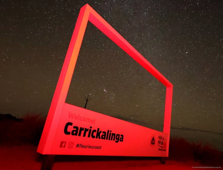 The bright signpost framing the night sky at Carrickalinga Lookout