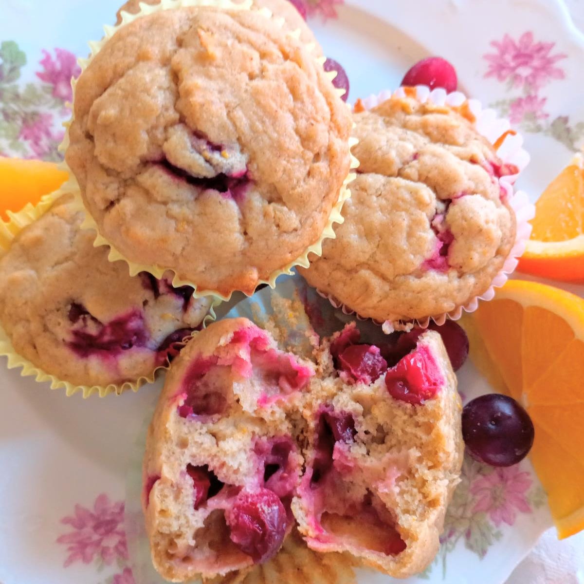 cranberry orange oatmeal muffins on plate with orange slices.