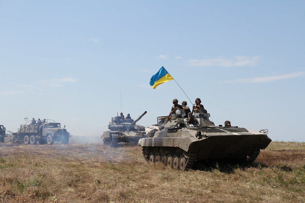 Des soldats ukrainiens sur des chars brandissent un drapeau de l'Ukraine lors d'une opération anti-terroriste à l'est du pays