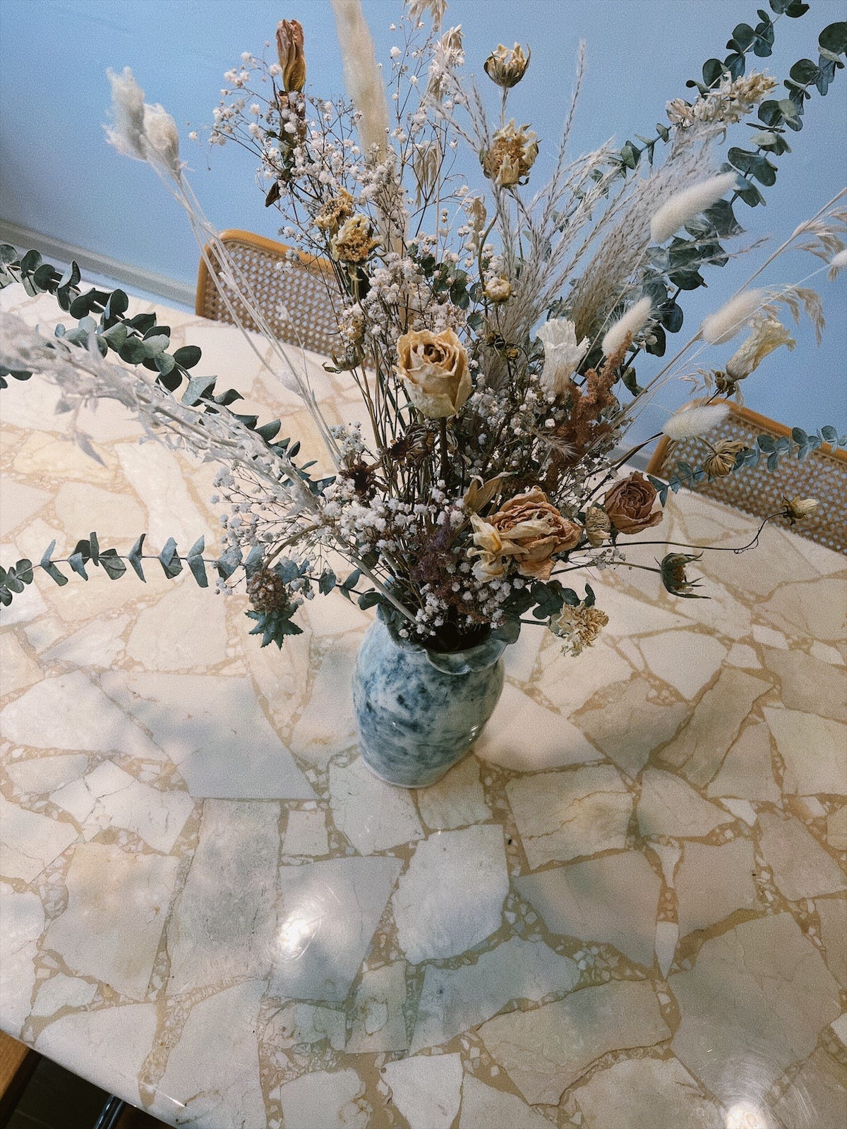 a solid stone vintage table with dried florals on top pictured at Evorden in Vancouver