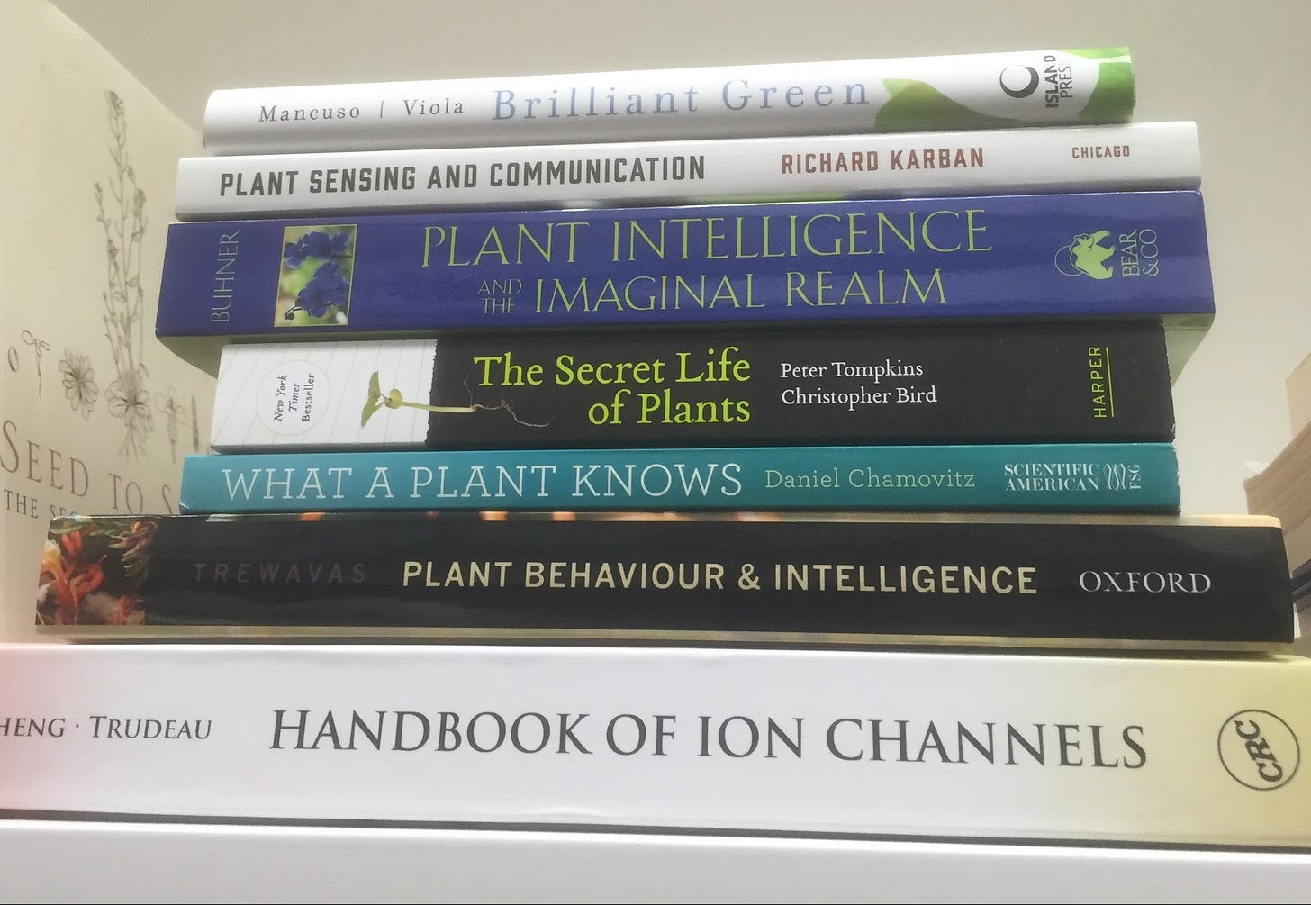 A stack of books about Plant Intelligence, including "The Secret Life of Plants" and others.