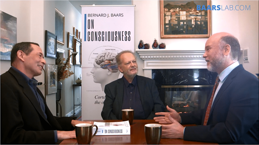 Three neuroscientists discussing consciousness and the brain at a table