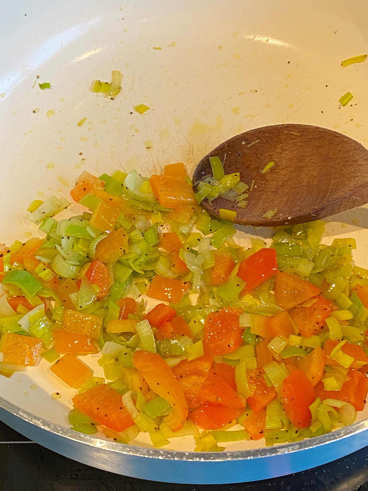 mixed vegetables frying in a large pan.