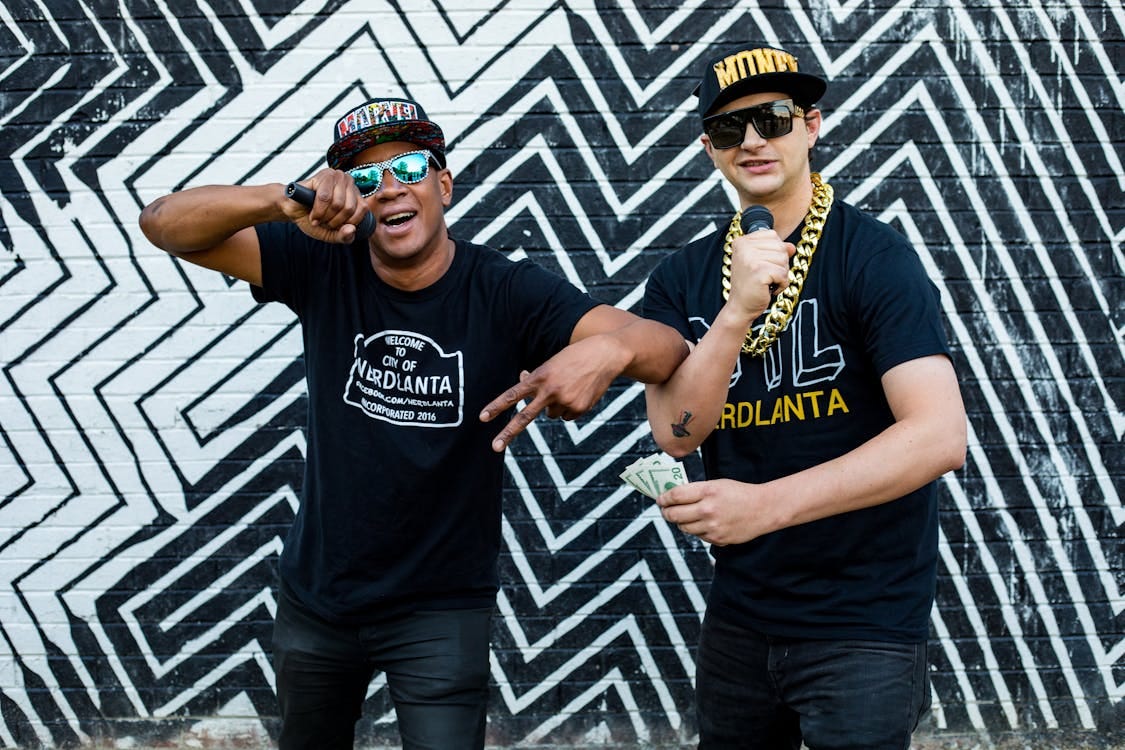Free Rap duo performing in front of Atlanta street art, exuding style and energy. Stock Photo