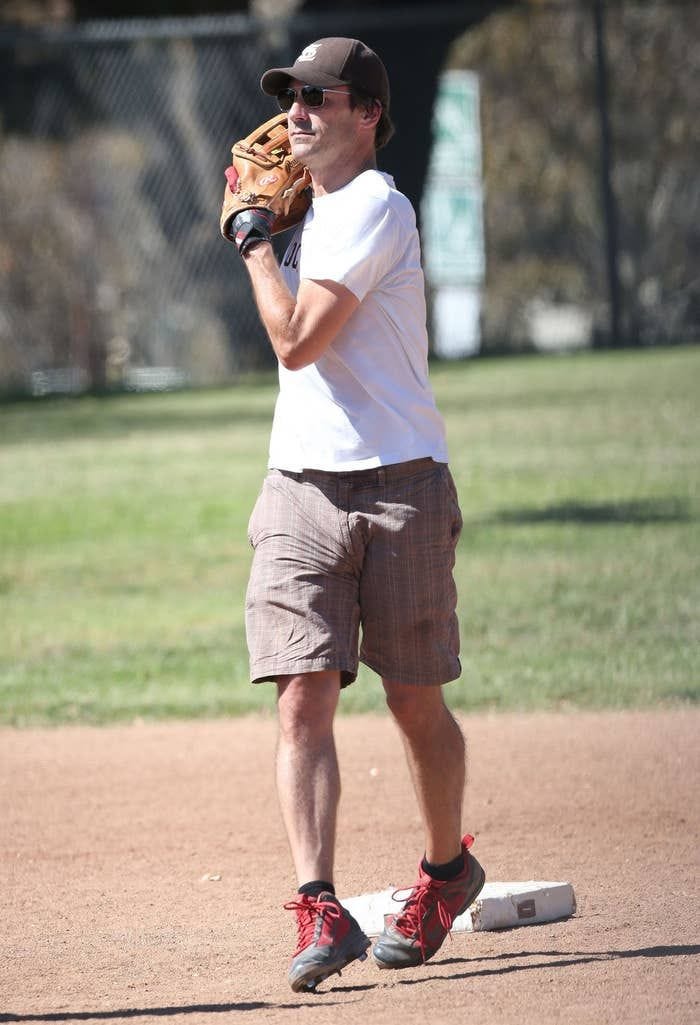 This may contain: a man standing on top of a baseball field holding a catcher's mitt