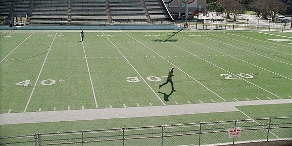 Cordell Walker running down football field as Geri walks off.