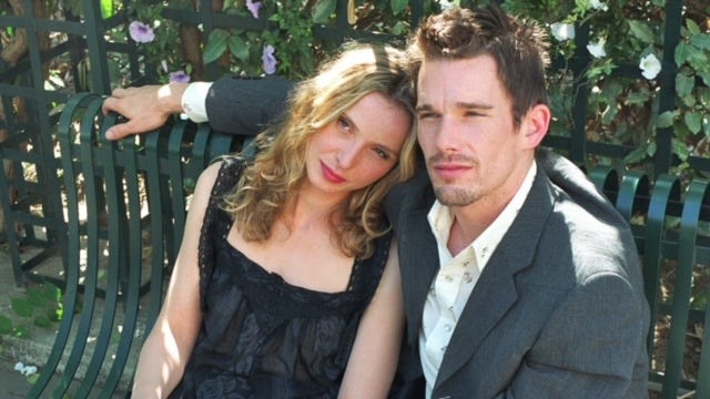 A screenshot from the movie "Before Sunset" showing the two main characters sitting on a park bench together