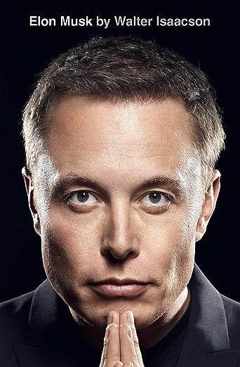 Cover of Walter Isaacson's biography titled 'Elon Musk'. It features a close-up portrait of Elon Musk with a serious expression, hands clasped in front of him, against a dark background. Musk's intensely focused eyes are a standout in this high-contrast image.