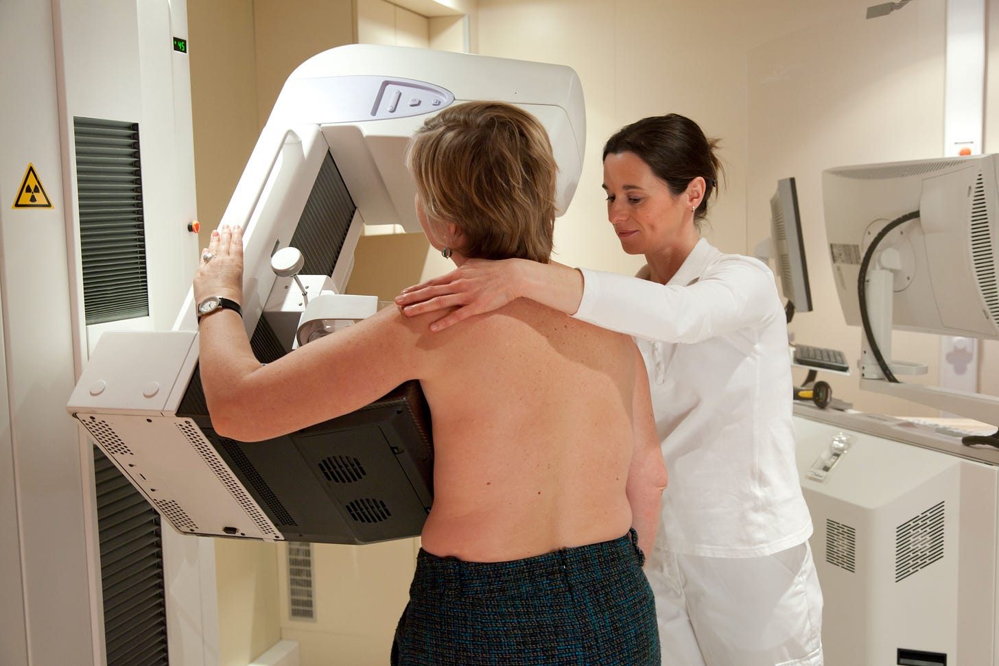 Radiology technician performs mammography test