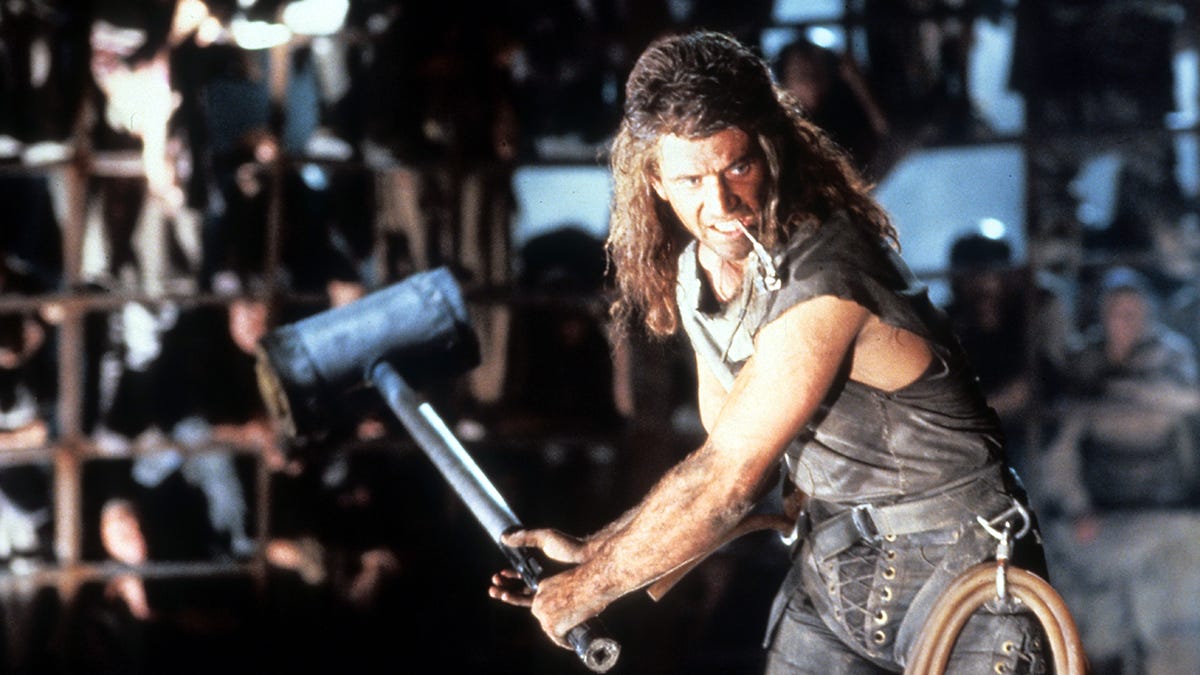 Mel Gibson as Mad Max with a big mullet, holding a bigger mallet inside the Thunderdome.