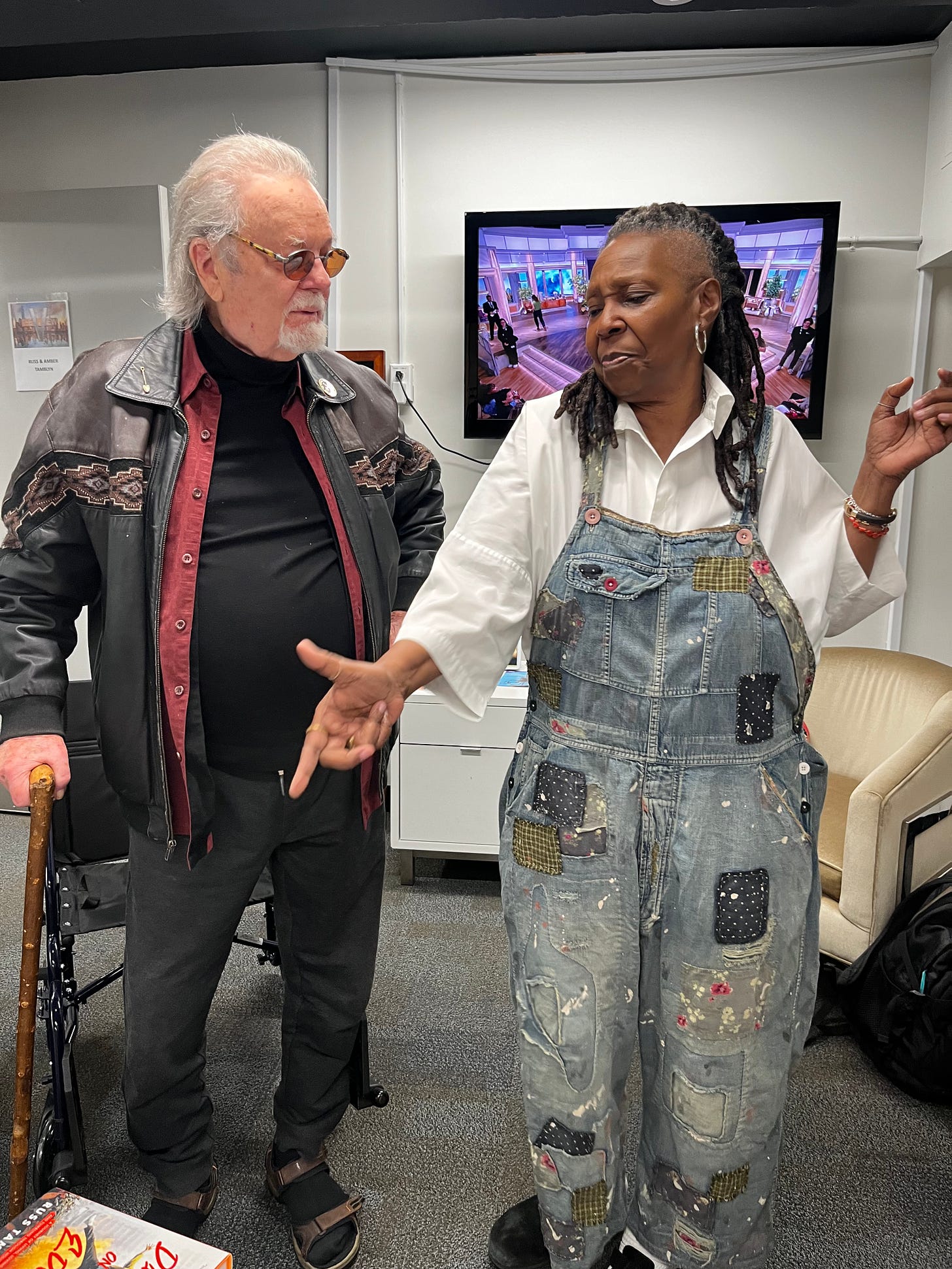 Russ Tamblyn and Whoopi Goldberg speak animatedly in "The View" greenroom. 
