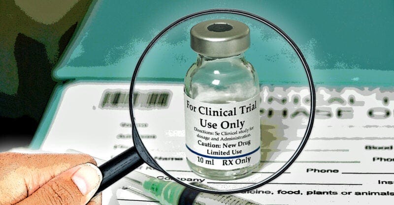 magnifying glass over a covid vaccine bottle "for clinical trial use only"