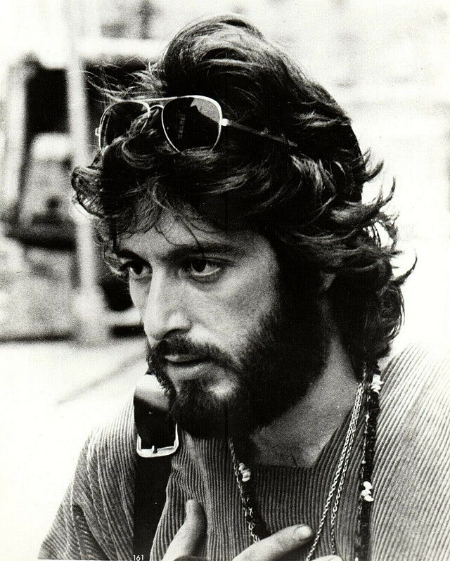 Black and white image of bearded Al Pacino with sunglasses on his head.