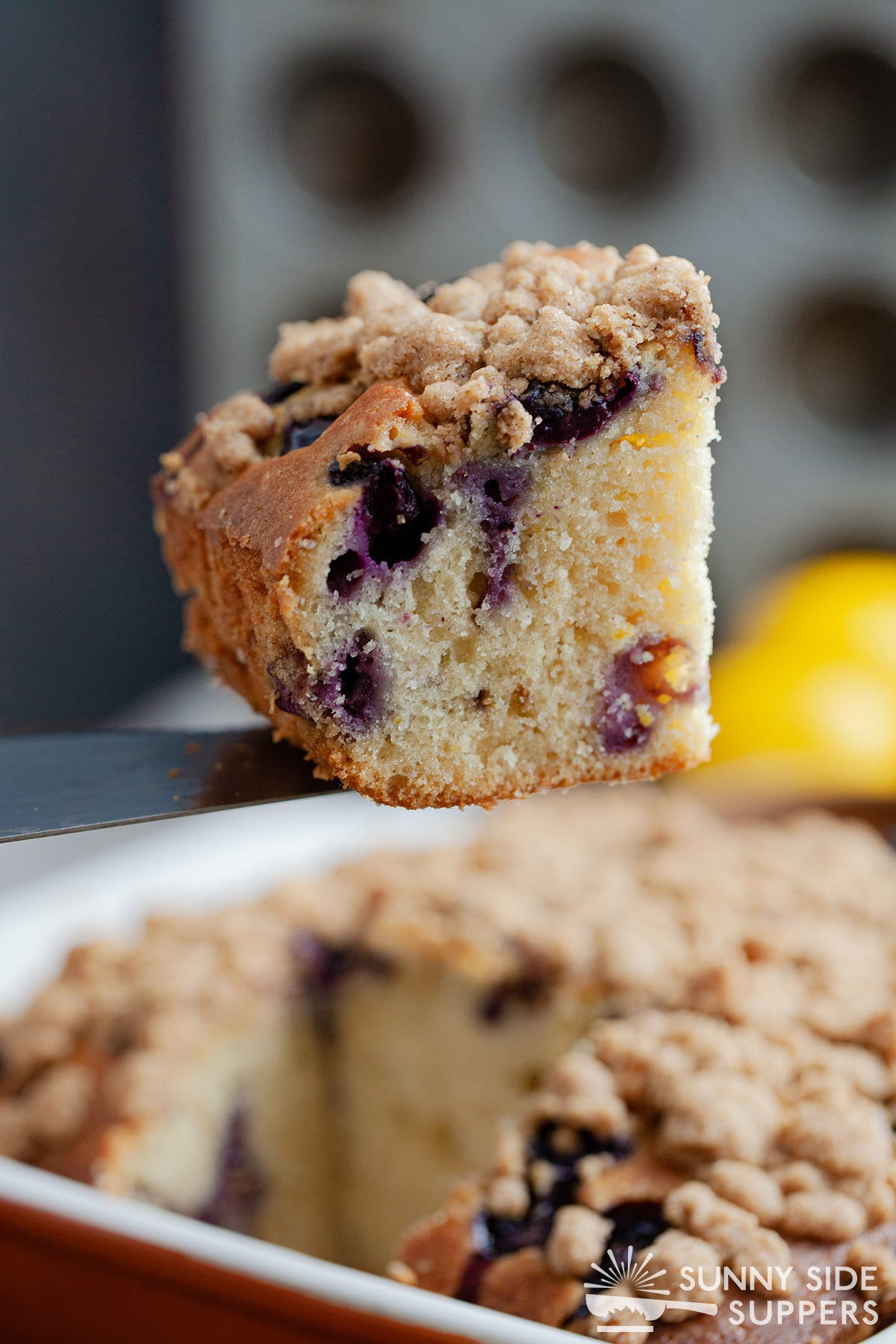 Spatula lifting a slice of sour cream coffee cake.