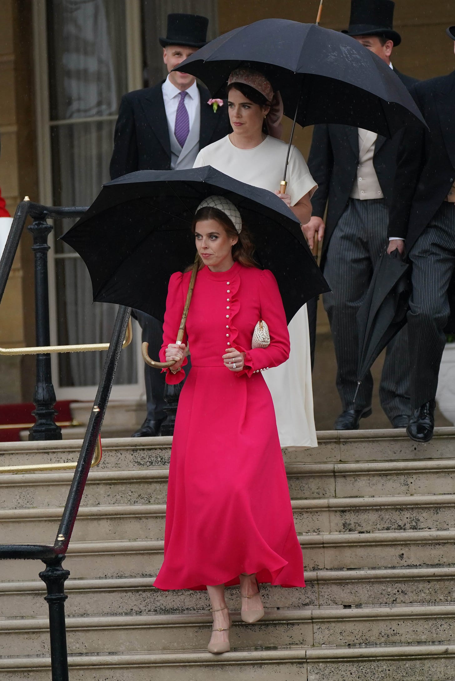 Beatrice and Eugenie holding umbrellas at garden party