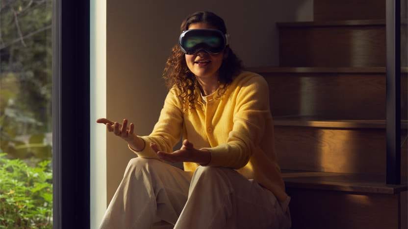 Woman sitting down on the stairs while wearing Apple Vision Pro