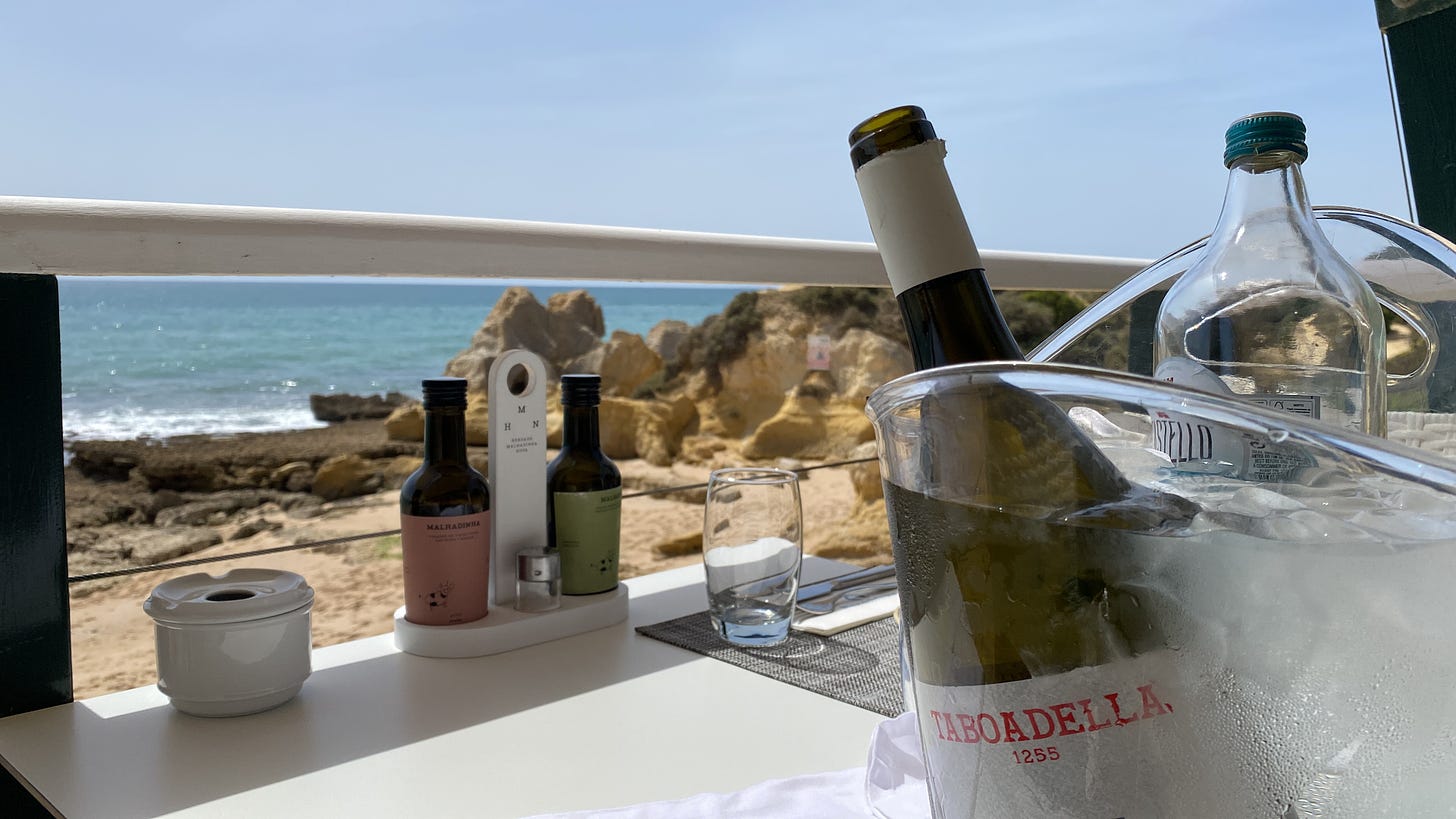 A bottle of delicious Taboadella wine chilling in an ice bucket looking out at the Atlantic ocean in the Algarve, Portugal 