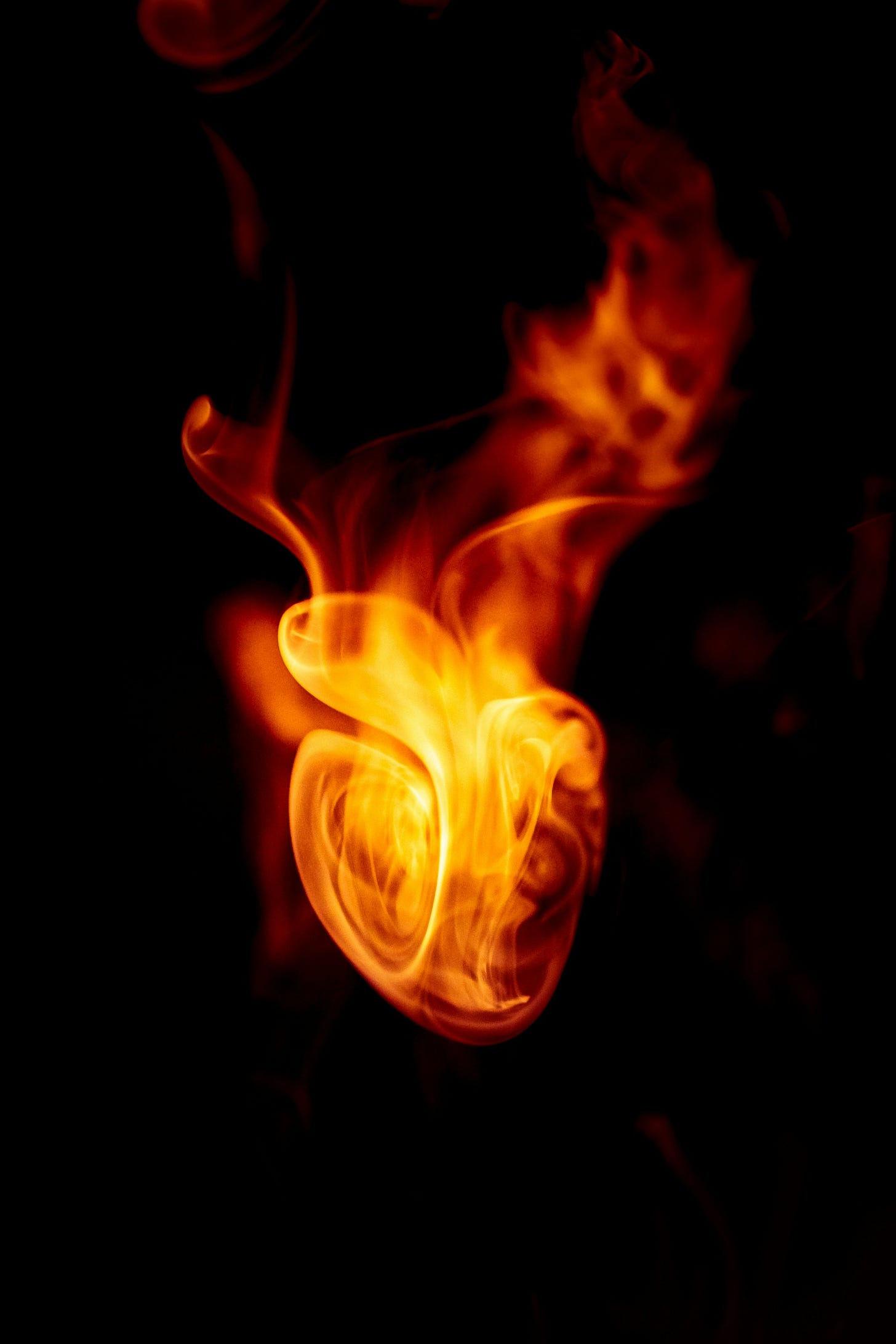 Red fire in the shape of a heart against a black background Red fire in the shape of a heart against a black background