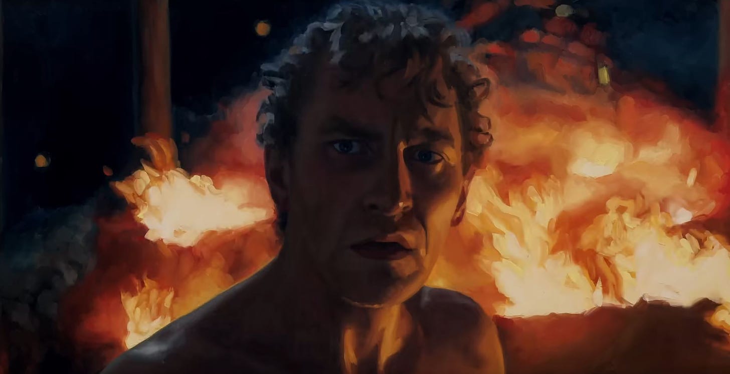 A screenshot from the movie The Peasants showing Antek in front of a blazing fire looking shocked.