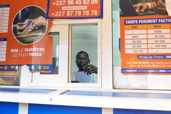 A money changer waits for customers in Niamey, Niger, Friday, Aug. 11, 2023. The ECOWAS bloc said it had directed a "standby force" to restore constitutional order in Niger after its deadline to reinstate ousted President Mohamed Bazoum expired. (AP Photo/Sam Mednick)
