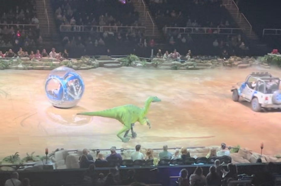 a dinosaur walks around the MVP arena