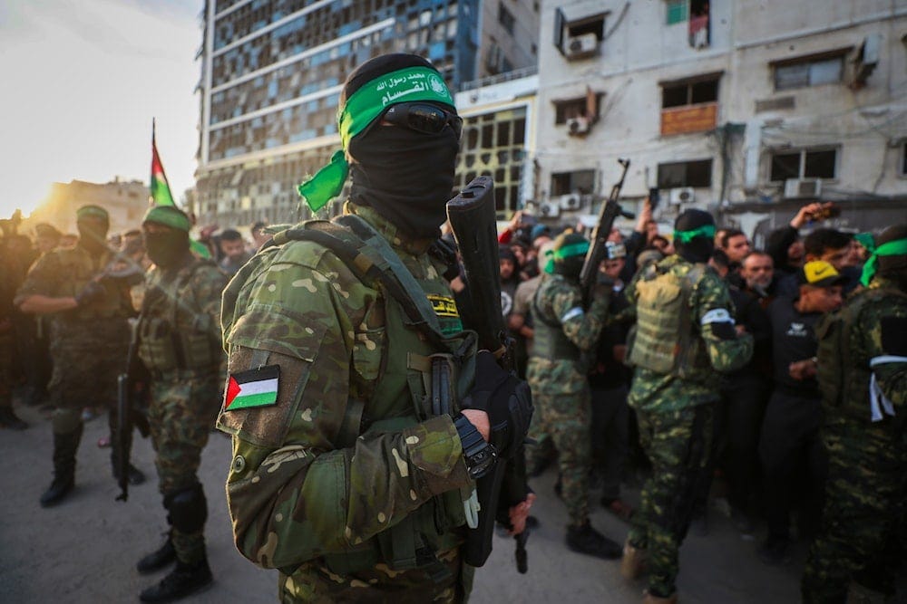 Fighters from the Qassam Brigades, the military wing of Hamas, control the crowd as Red Cross vehicles come to collect Israeli hostages under a ceasefire agreement between Israel and Hamas, in Gaza City, on January 19, 2025. (AP)