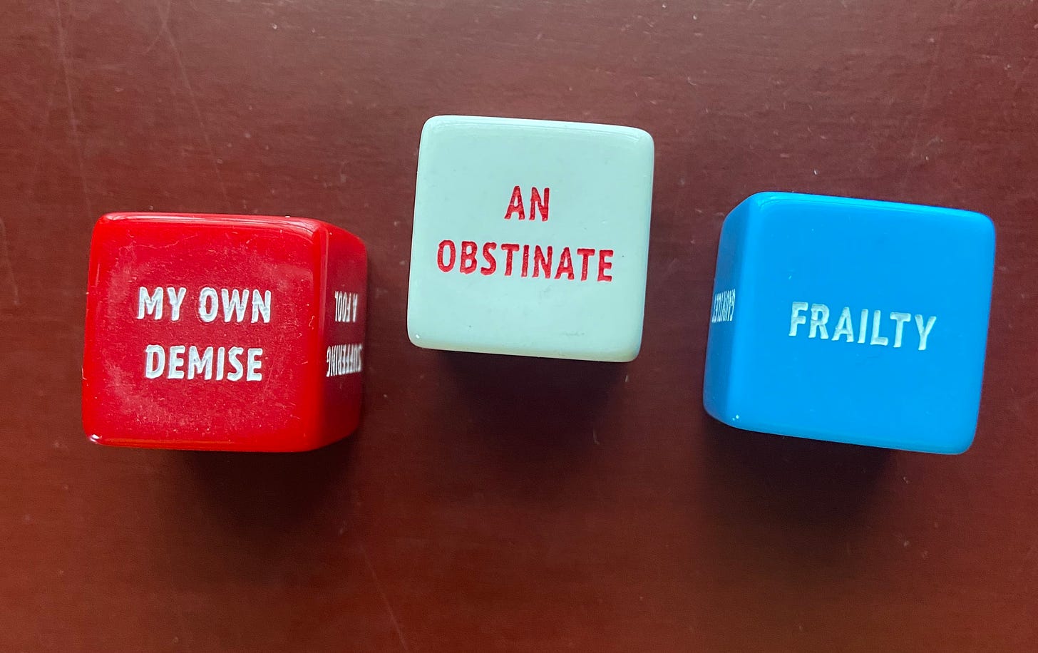 Red dice says: MY OWN DEMISE, white dice says: AN OBSTINATE, and blue dice says, FRAILITY