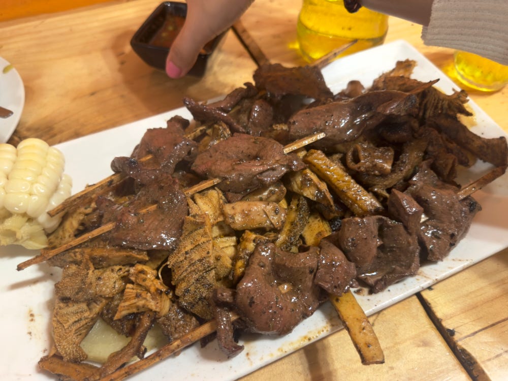 A heaping plate of grilled anticuchos and other grilled meats