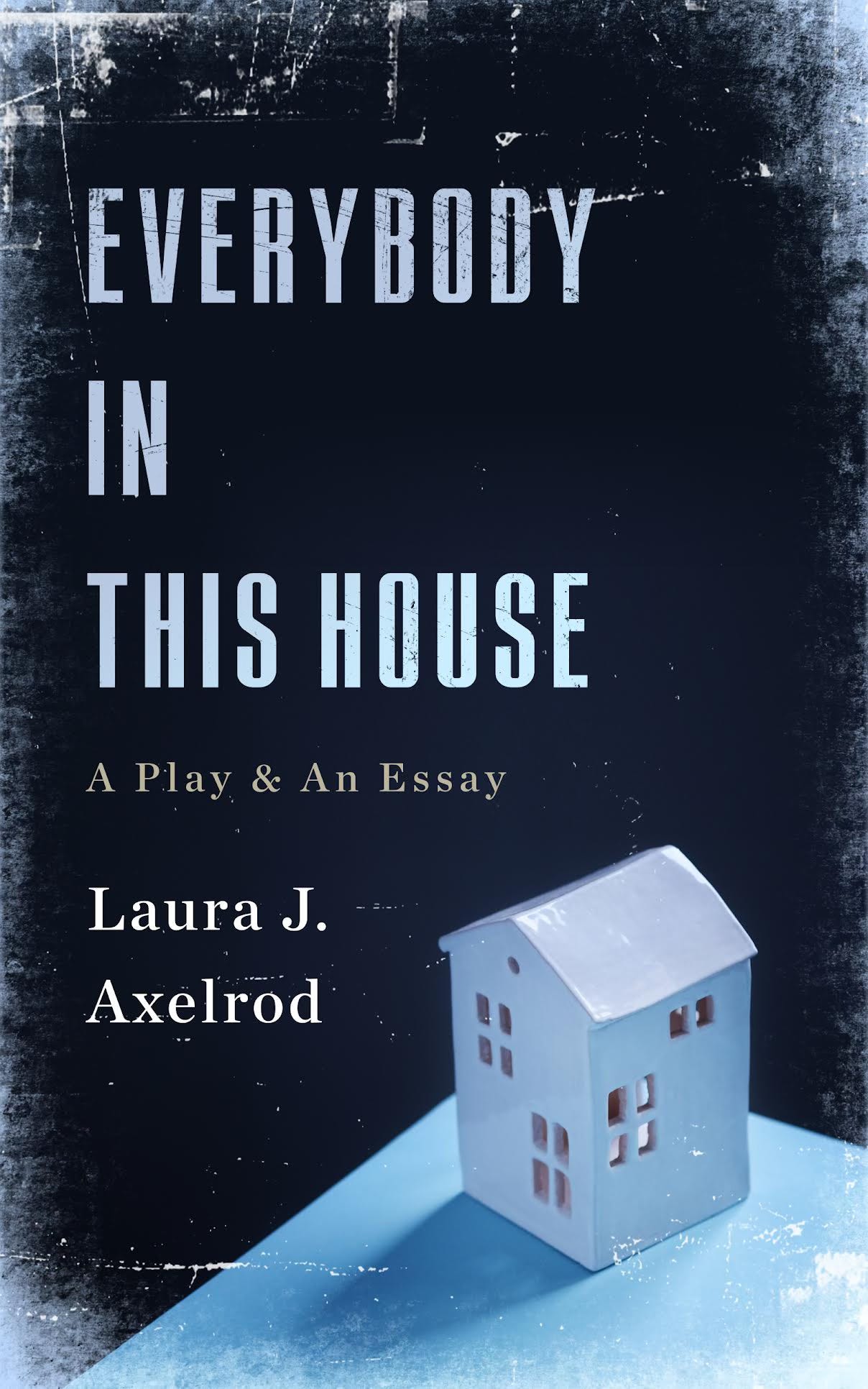 A book cover that looks worn with a wooden house on a table