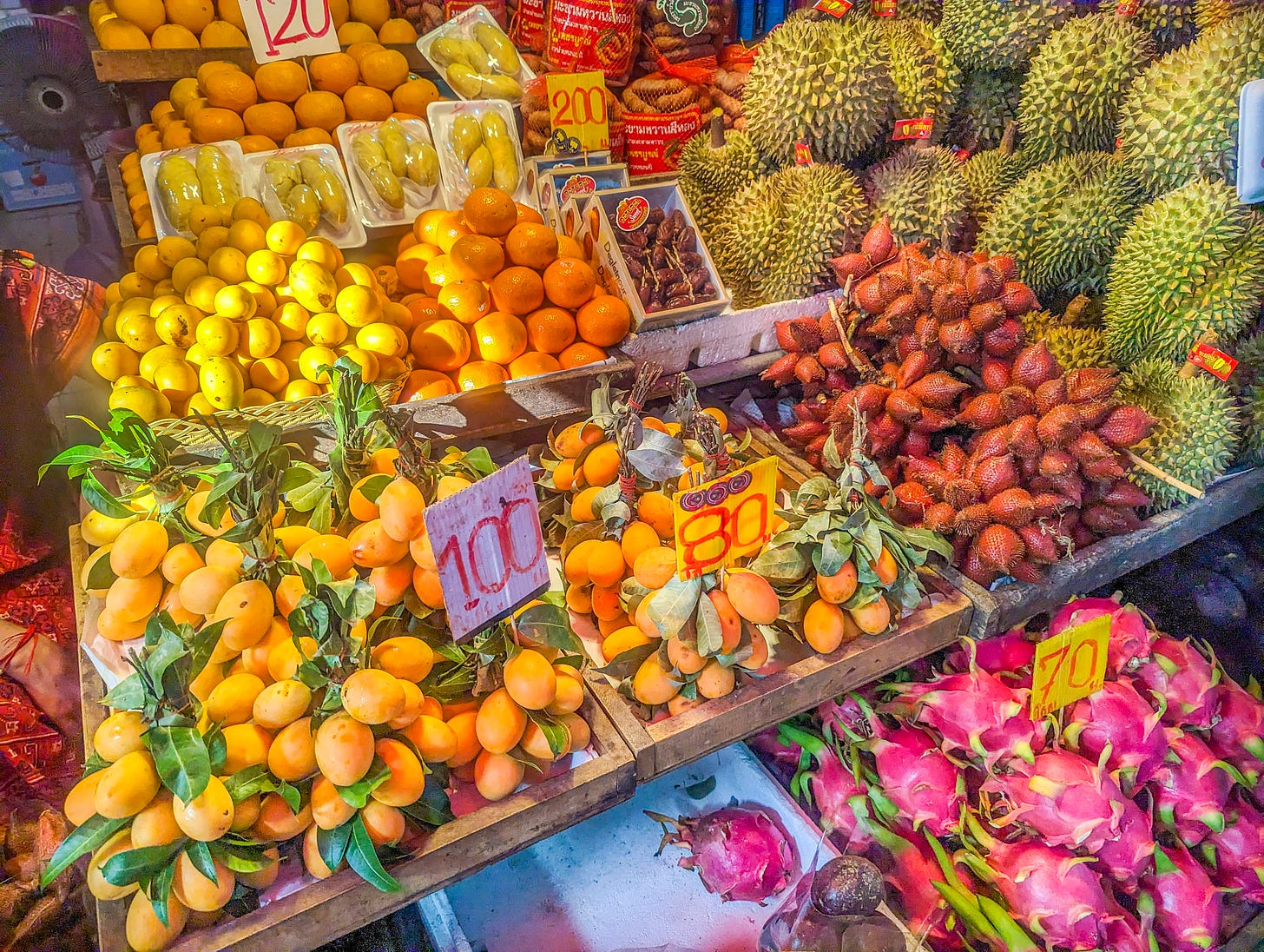 Colorful display of citrus, durian, and and dragon fruit. 