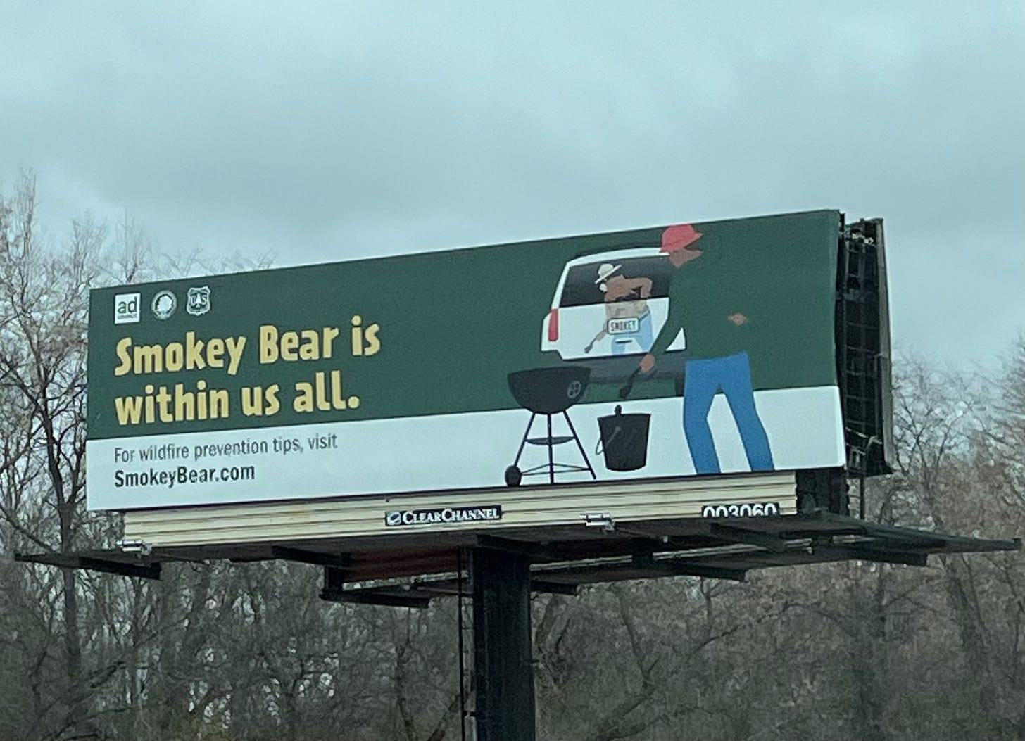 A billboard that reads Smokey Bear is within us all with a note about wildfire prevention tips 