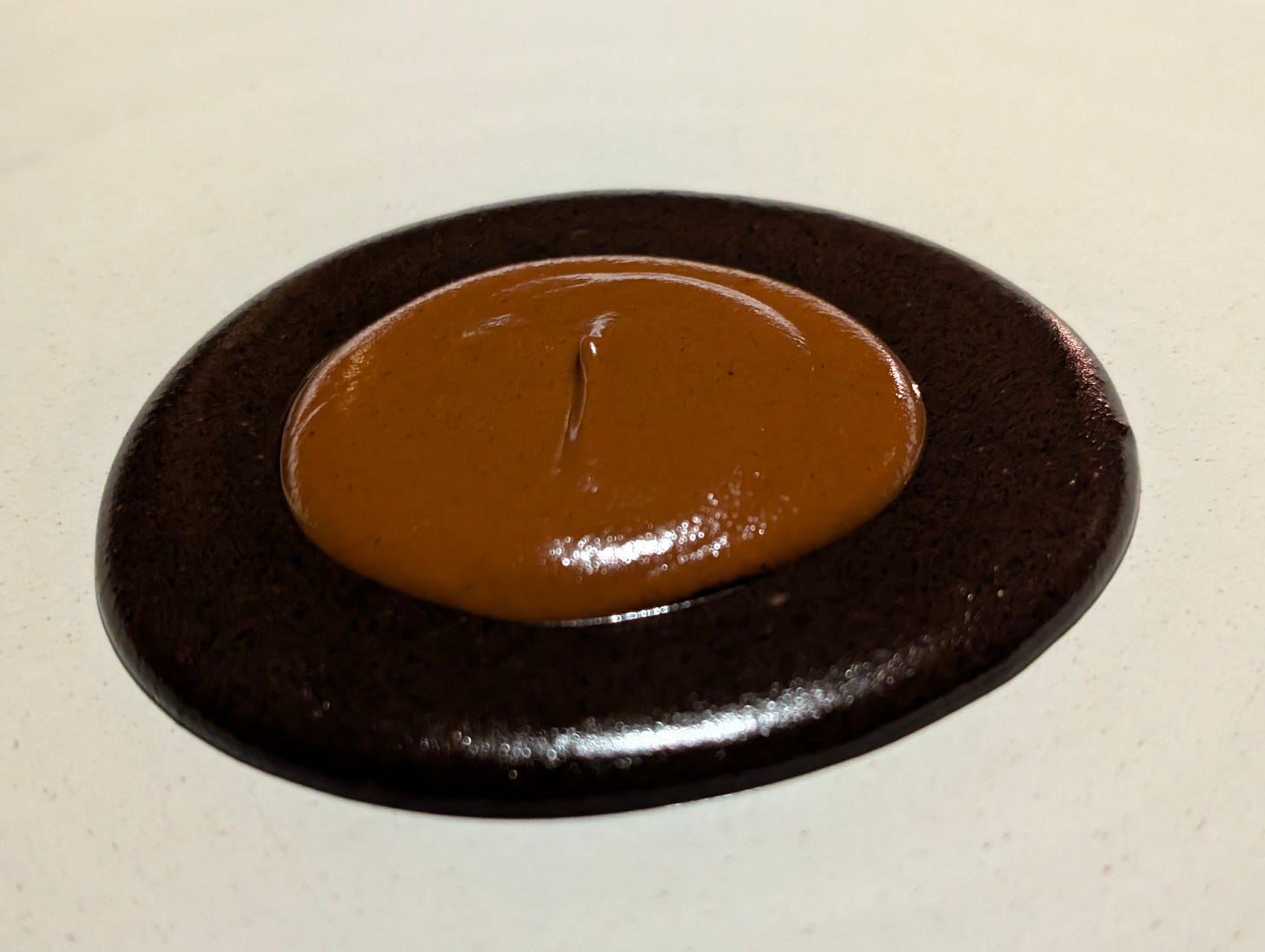 The mole madre at Pujol with a lighter mole served inside a darker, older mole