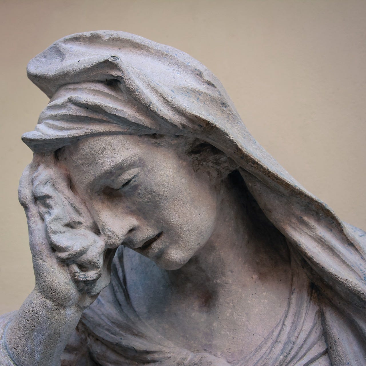 A statue in the classical style of a woman (probably the Virgin Mary; it's always the Virgin Mary) resting her forehead in her hand in the classic "facepalm" gesture. She's wearing a veil or head covering and holding a cloth in that hand as well.