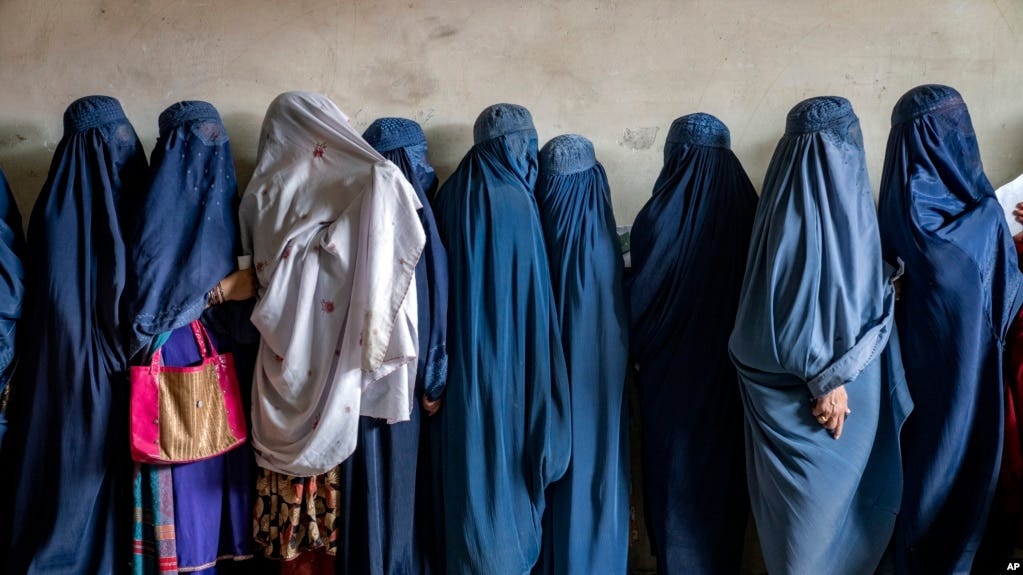 FILE - Afghan women wait to receive food distributed by a humanitarian aid group in Kabul, Afghanistan, on May 23, 2023. The United States on Dec. 8 imposed sanctions against two Taliban leaders for human rights abuses against women and girls.